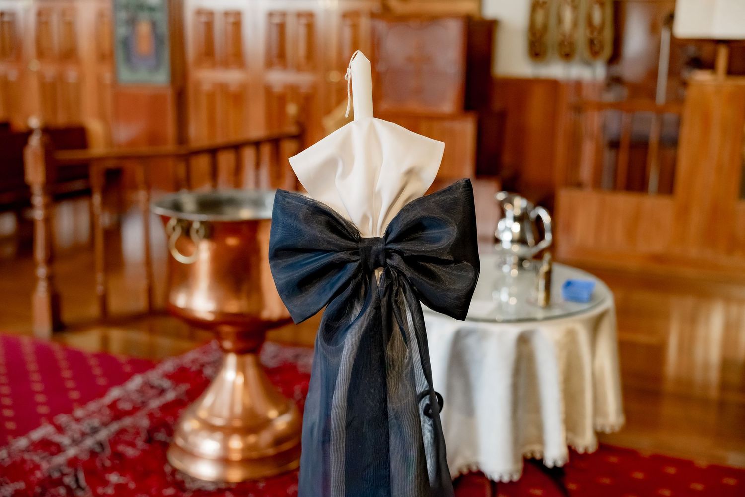 Interior view of church pews with dark blue sashes for a baptism ceremony.