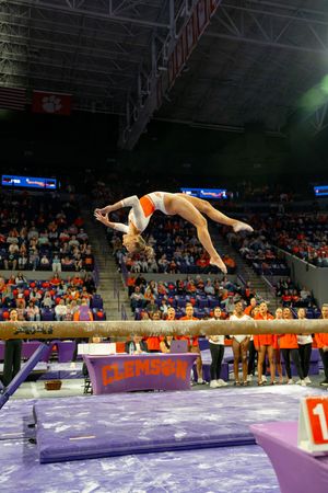 Clemson gymnast performs a back flip on the balance beam during a college gymnastics meet at Littlejohn Coliseum.