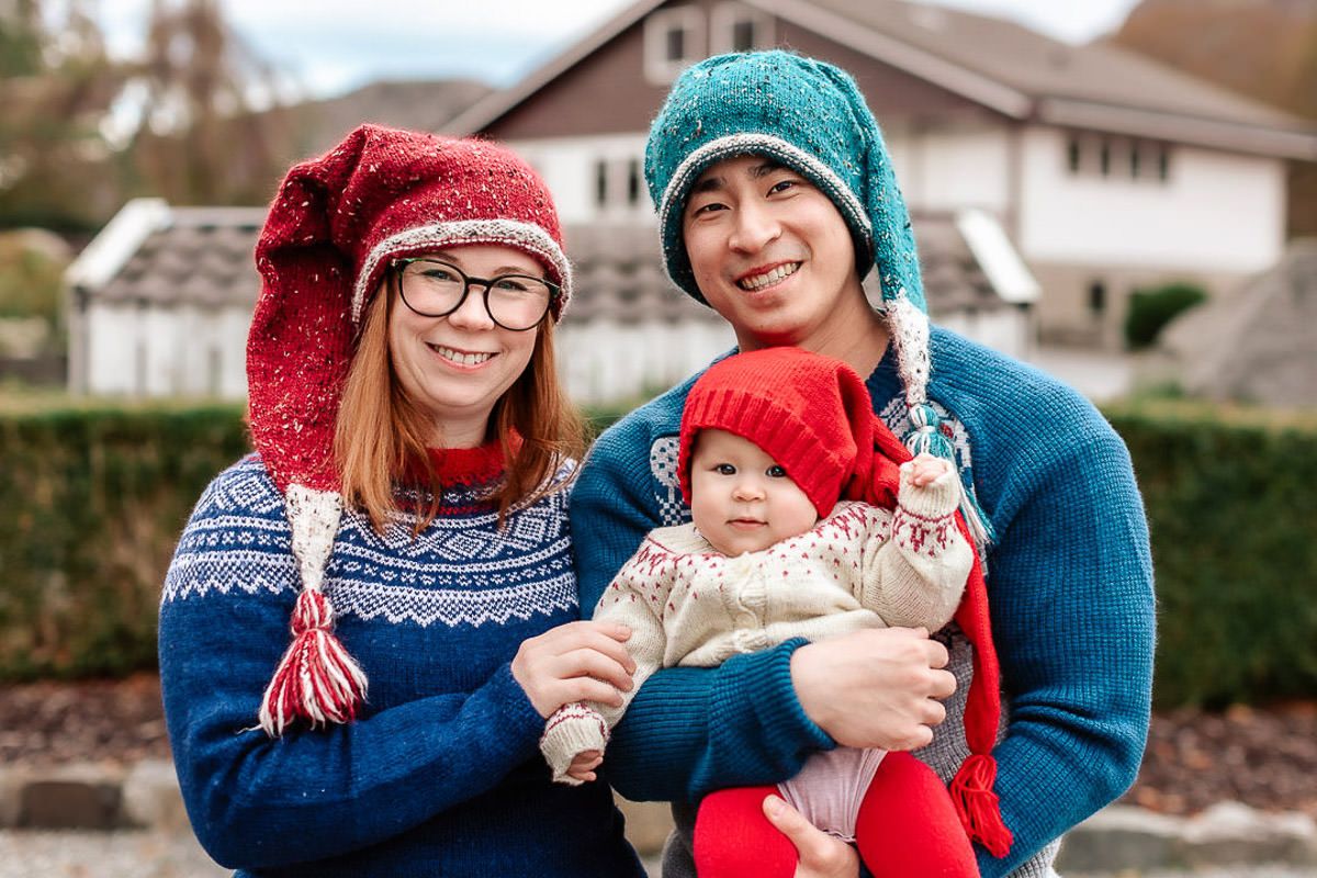 Mor, far og datter med strikkegensere og nisseluer på julekortfotografering på Ålgård med Ørstavik Foto.  Alle smiler til kamera.