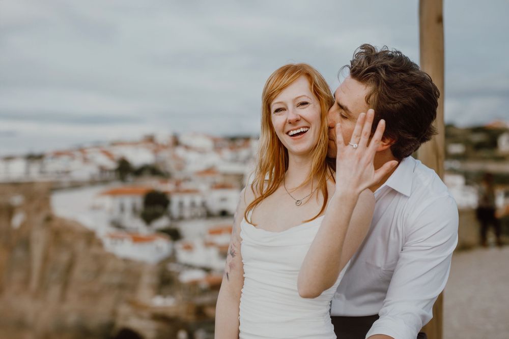 A couple shares intimate moments together during a coastal engagement photo session at sunset.