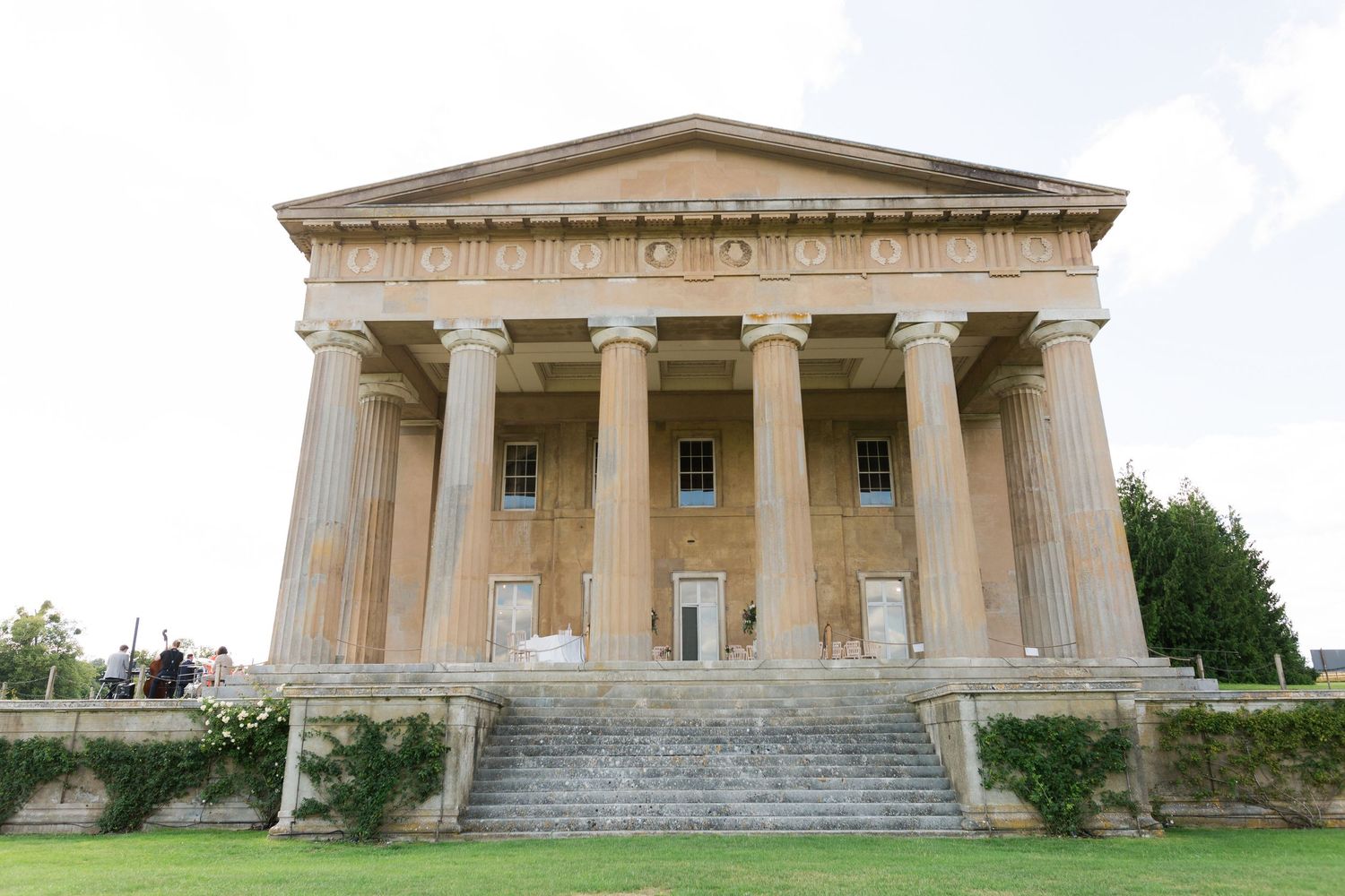 Panoramic view of a neoclassical building with columns and triangular pediment in a rural setting at The Grange Northington