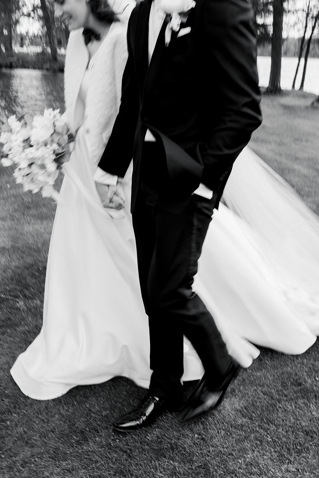 Black and white wedding photo series showing close-up details of a bride and groom's feet dancing on grass.