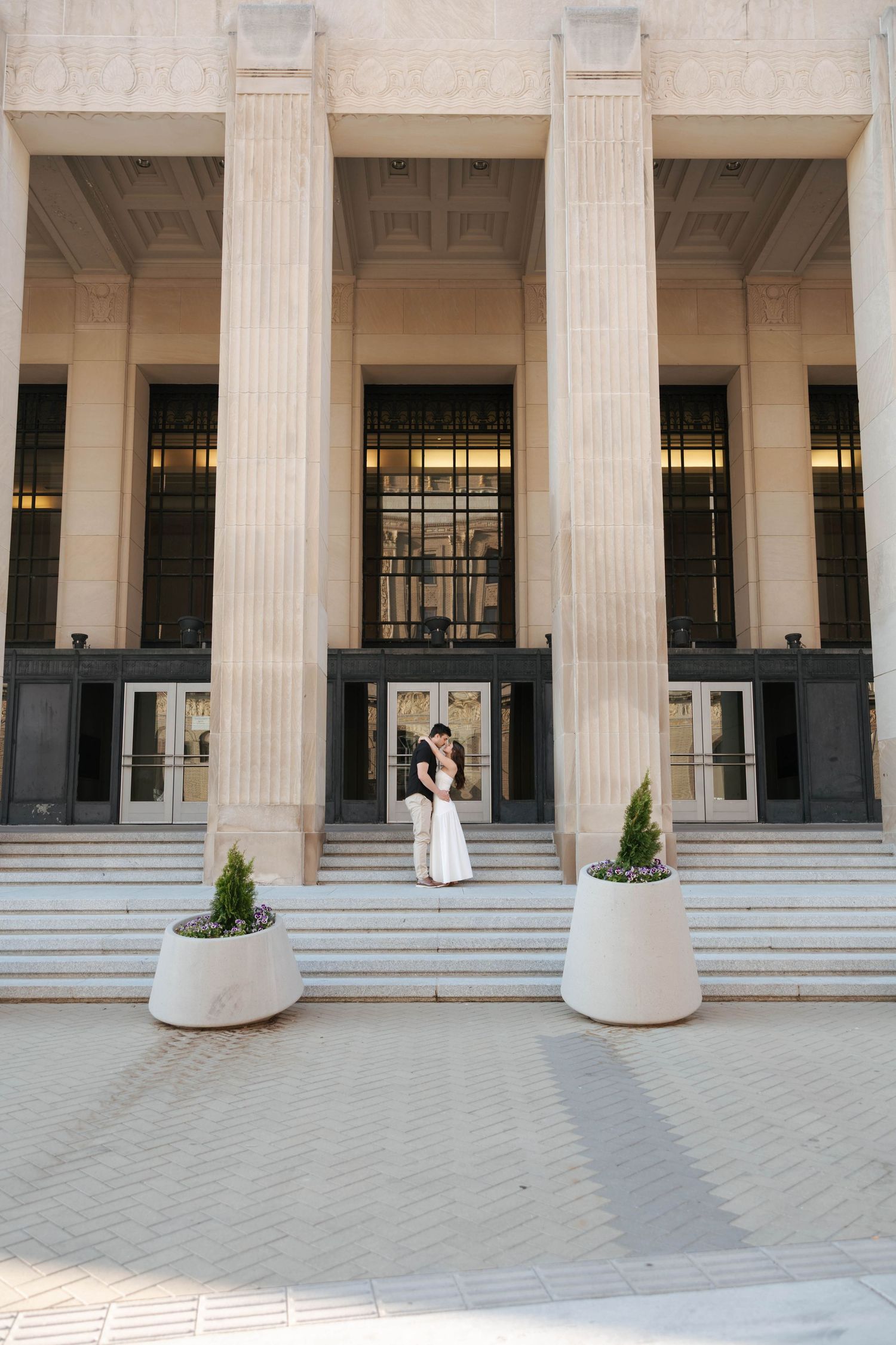 A couple in wedding attire dances together at a reception venue with elegant lighting and decor.
