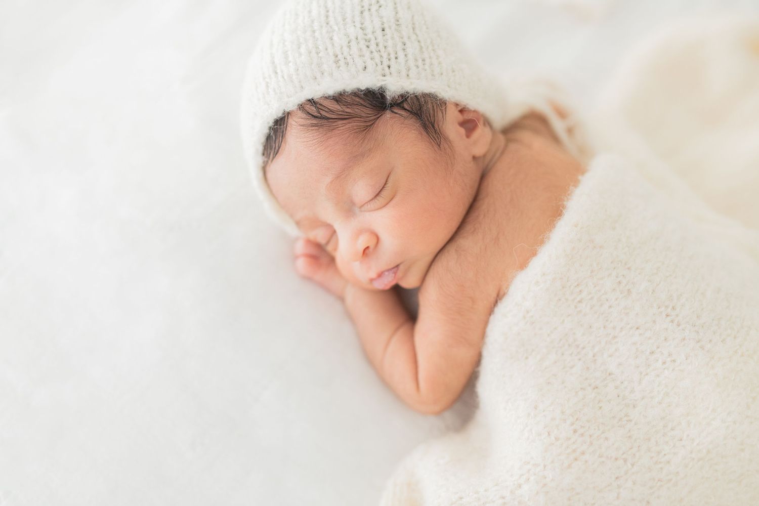 Sweet newborn baby peacefully sleeping on their belly, captured in a serene moment during a professional newborn photography session.