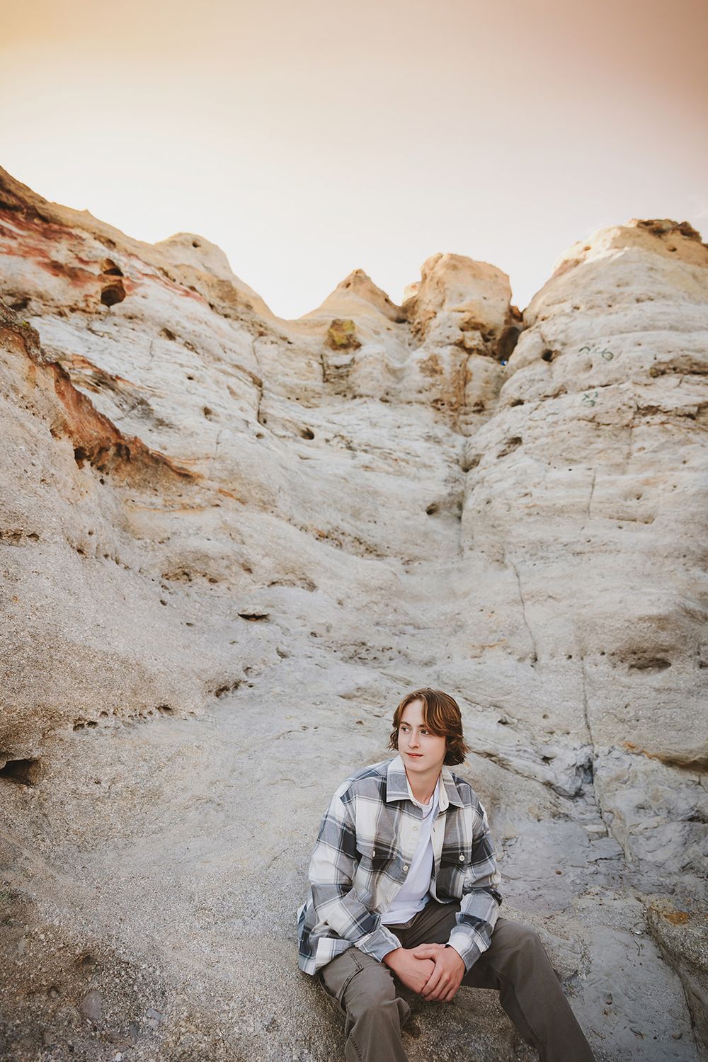Dramatic white rock formations create backdrop for outdoor portrait.