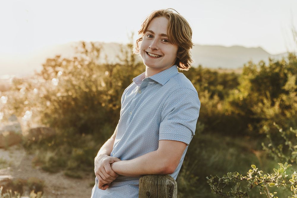 Casual portrait in light blue polo shirt during golden hour outdoors.