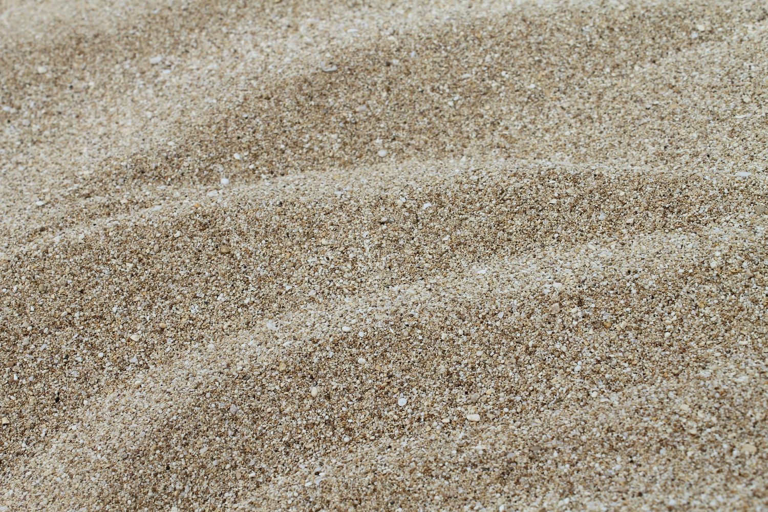 Smooth beige sand texture with gentle wave patterns.