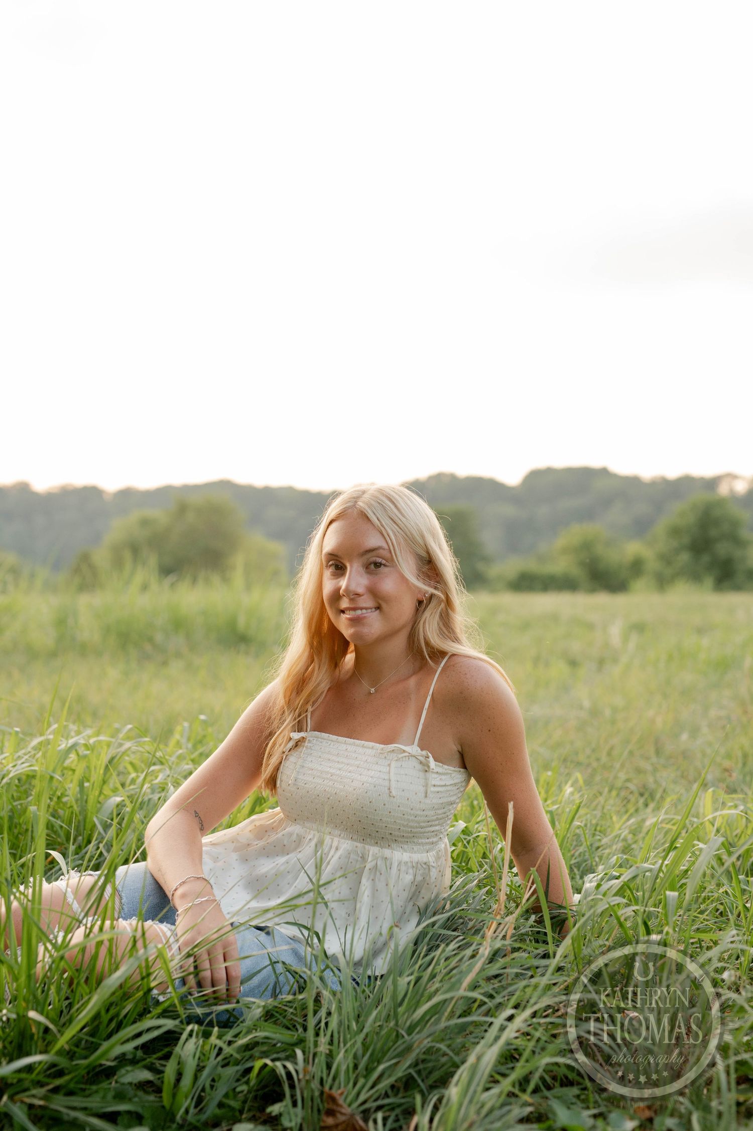 Natural outdoor portrait among tall grass with golden evening light.