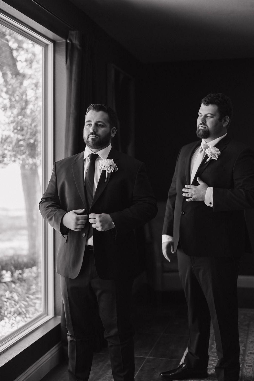 Black and white photos show groomsmen adjusting their ties and boutonnieres while standing near a window.