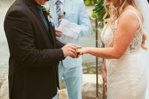 Elegant wedding ceremony scene with guests gathered on manicured lawn under string lights.