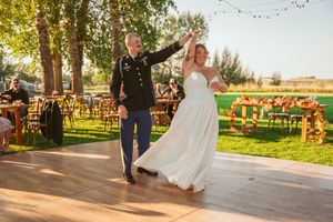 String lights and outdoor decor create an elegant rustic setting for a twilight reception at a barn wedding venue.