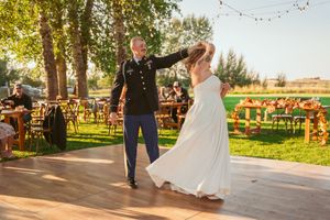 String lights and outdoor decor create an elegant rustic setting for a twilight reception at a barn wedding venue.