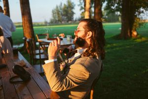 People enjoying drinks at an outdoor patio table during golden hour sunset lighting.