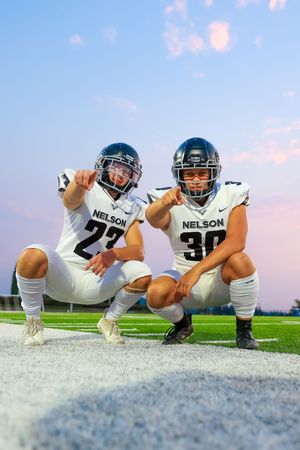 Football players in white uniforms and green helmets lined up on a football field at dusk in a creative sequence shot.