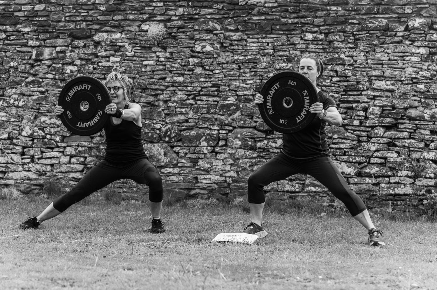 Series of dynamic jumping poses photographed against stone wall in black and white.