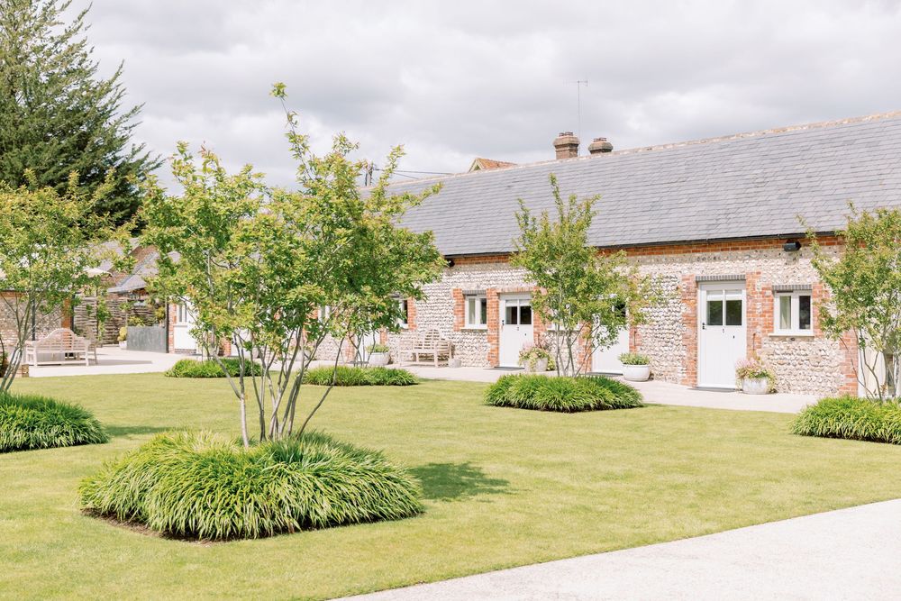 Brick country venue with manicured lawn and landscaped garden beds.