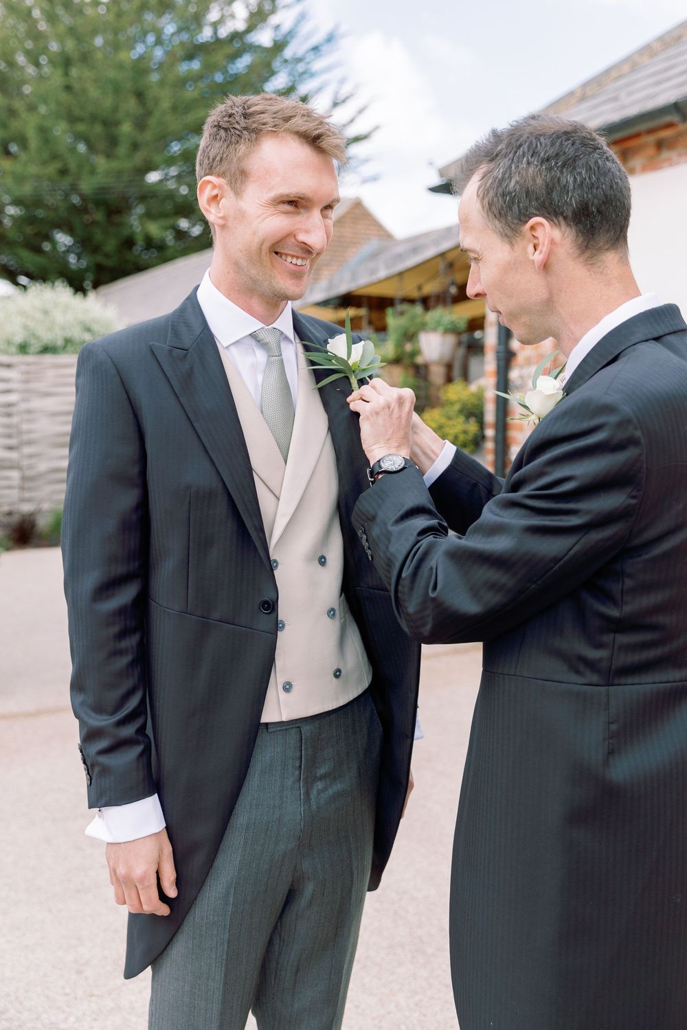 Final adjustments being made to formal wedding attire outdoors.