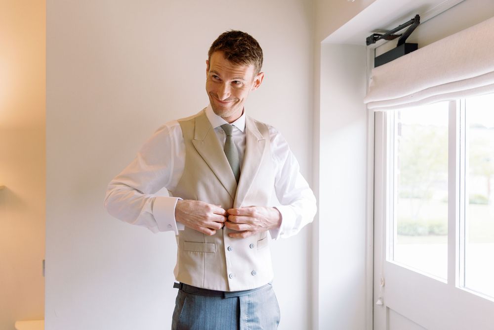 Wedding morning preparations in a bright sunny room with elegant attire.