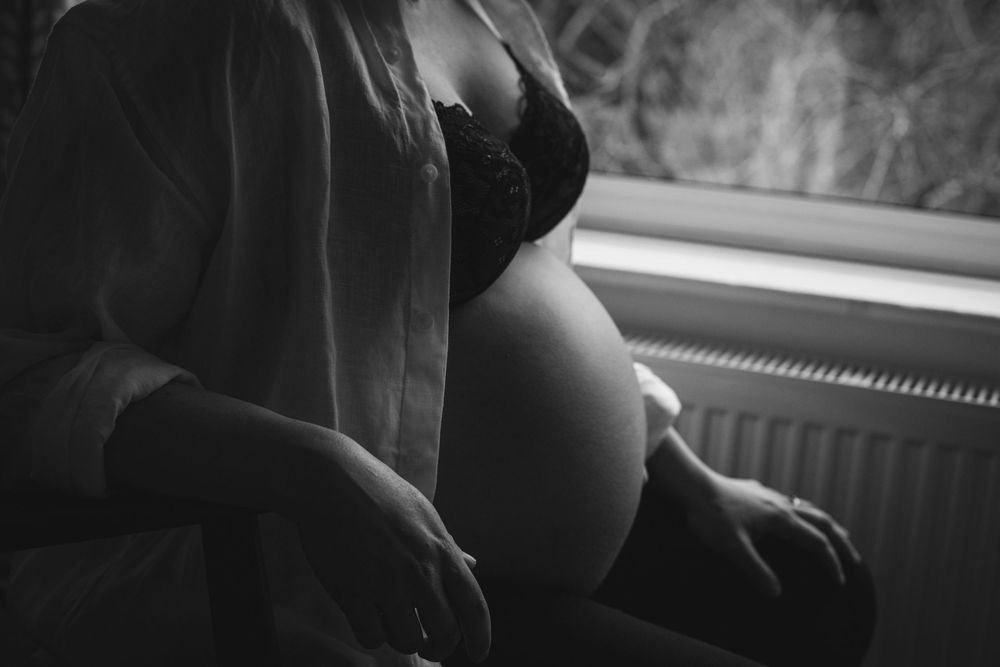Black and white silhouettes of figures against bright windows illustrate an intimate indoor scene with natural lighting.