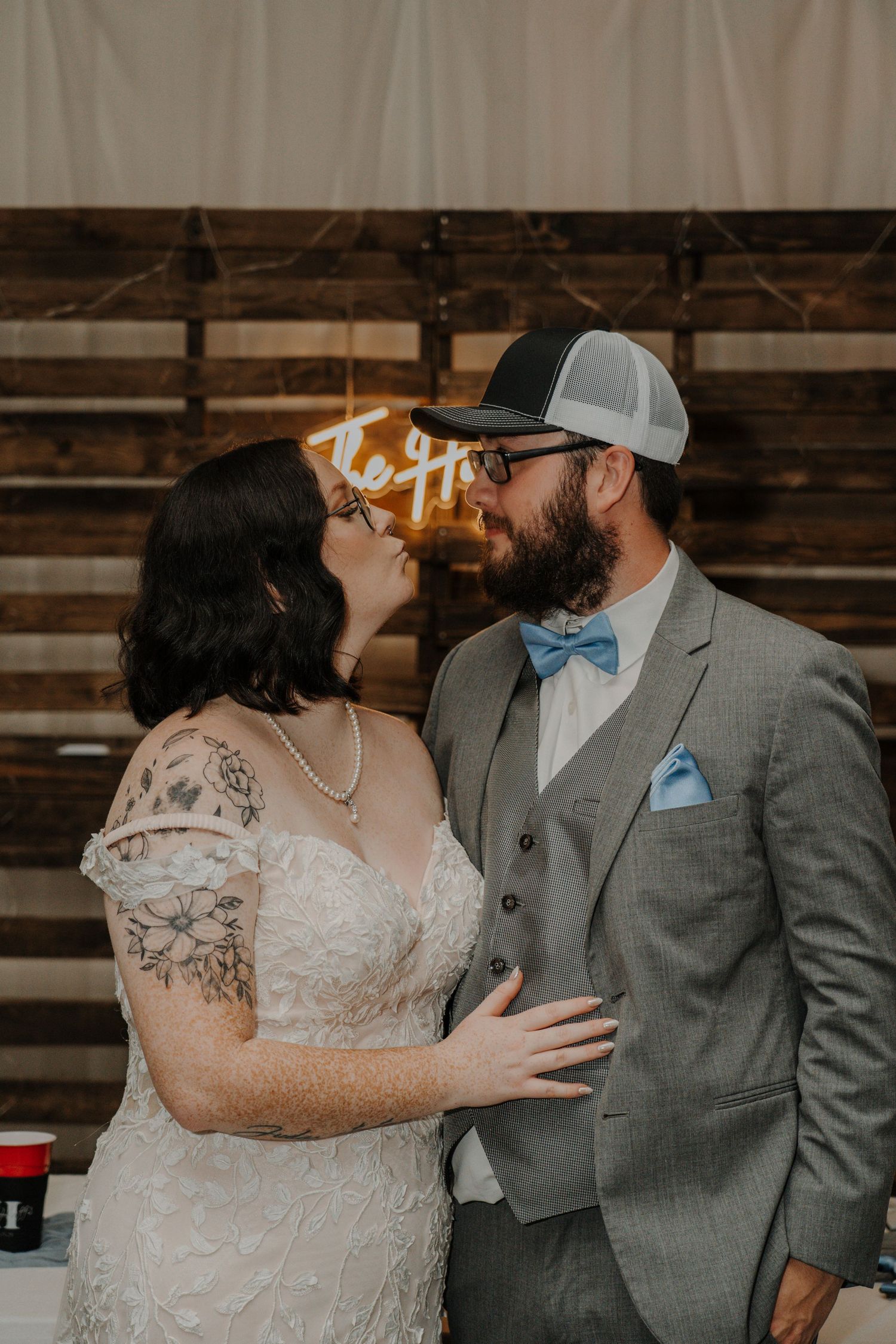 Wedding couple sharing intimate moment in rustic barn setting.