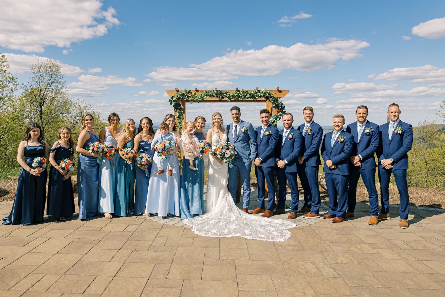 A series of wedding party photos lined up showing bridesmaids in burgundy dresses and groomsmen in black suits outdoors.