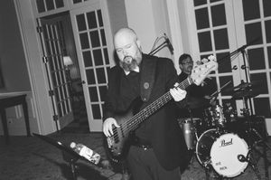 Black and white photos show musicians performing live on stage with guitars and drums during a concert.