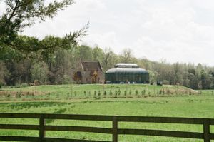 A collection of panoramic photos showing a rural landscape with split-rail fences, green pastures and a farmhouse in the distance.