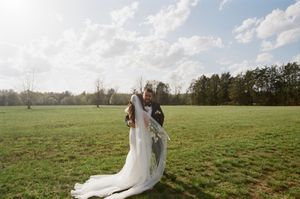 A romantic outdoor wedding sequence shows a newlywed couple embracing across a serene green meadow on a misty afternoon.