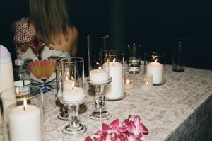 Elegant table setting with white pillar candles and pink orchids for a romantic wedding reception.
