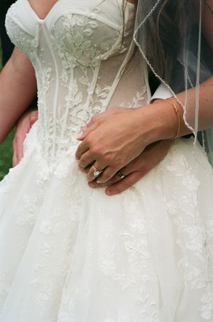Close-up details of an ornate white lace wedding dress with delicate beading and embroidery.