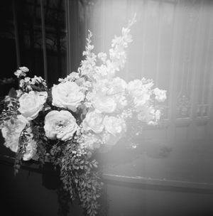 A black and white photograph of an elegant floral arrangement with roses and delicate blooms in a soft focus.