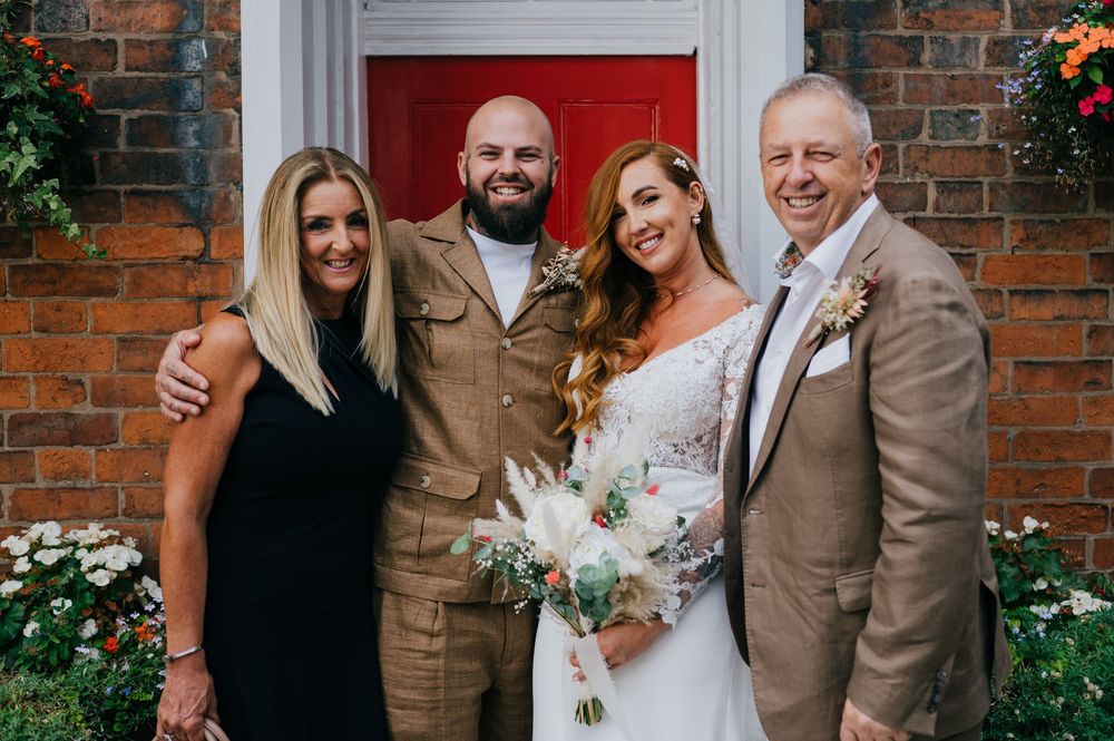 A collage of five wedding photos featuring couples and family posing against a brick wall with red door and floral decor.