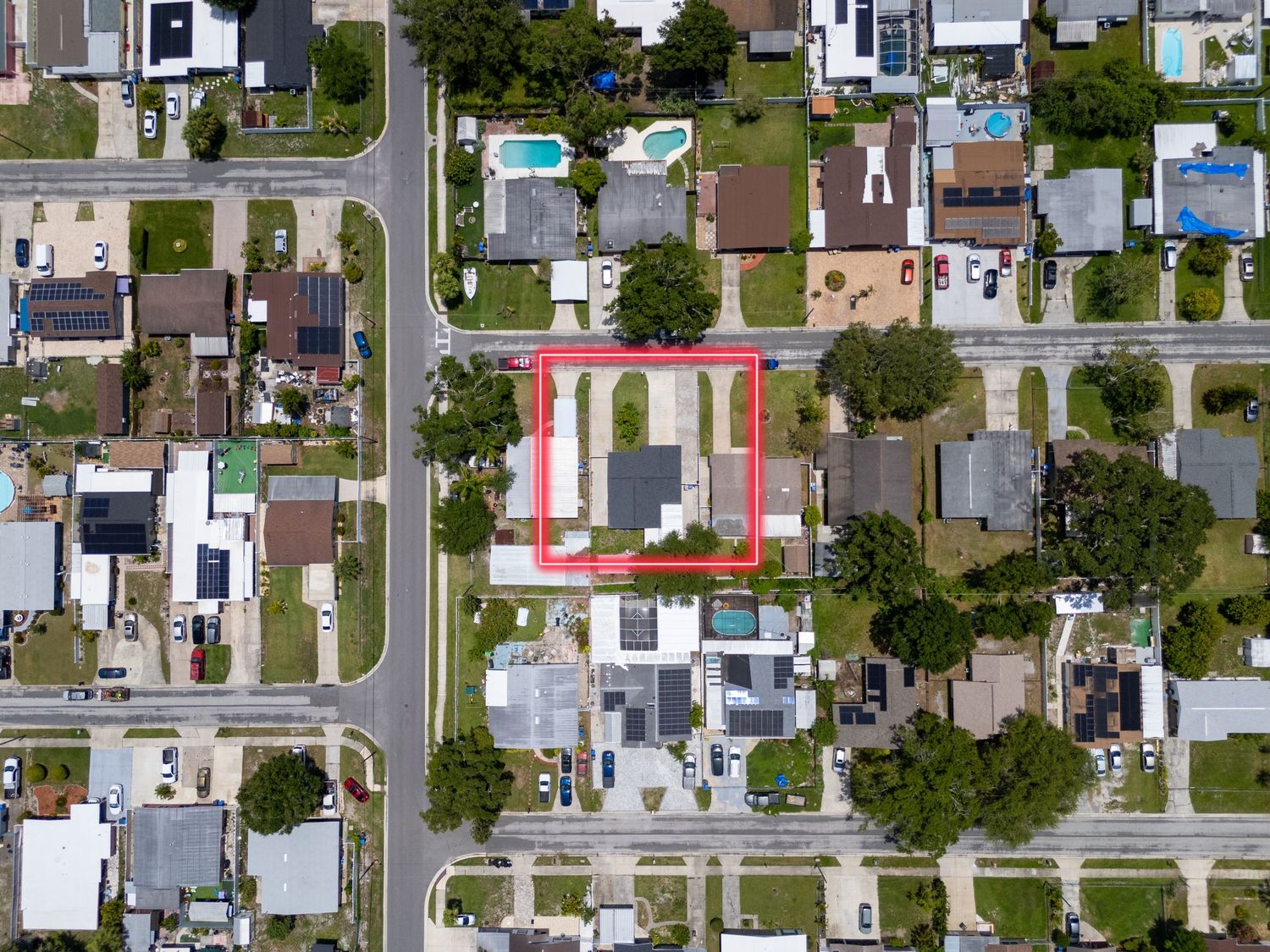 Aerial view of residential neighborhood with red outline highlighting a specific property lot.