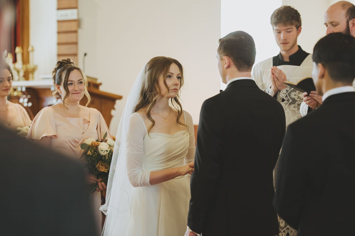 Bride and groom exchange vows during Latin Mass wedding.