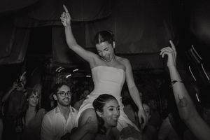 Black and white photo of people dancing with raised arms at what appears to be a nightclub or party.
