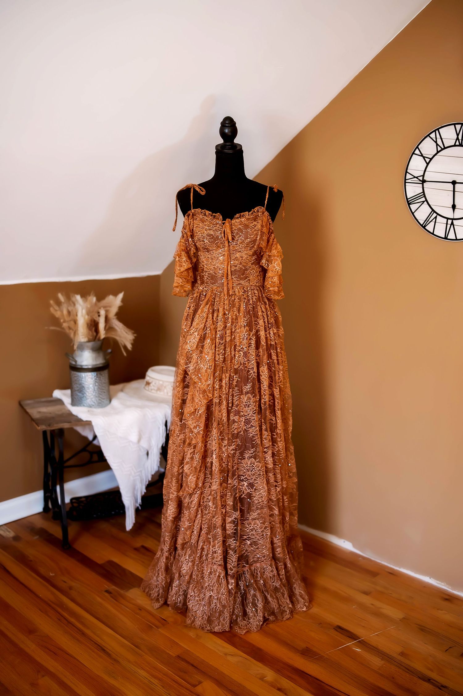 A flowing white empire waist dress on a mannequin shown from different angles on a hardwood floor.