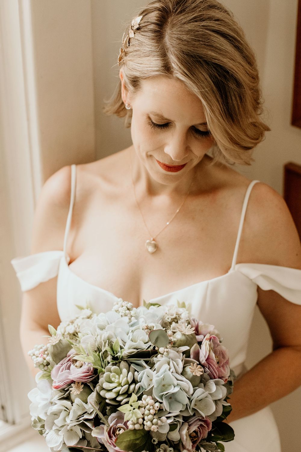 A new bride looking down at her wedding bouquet