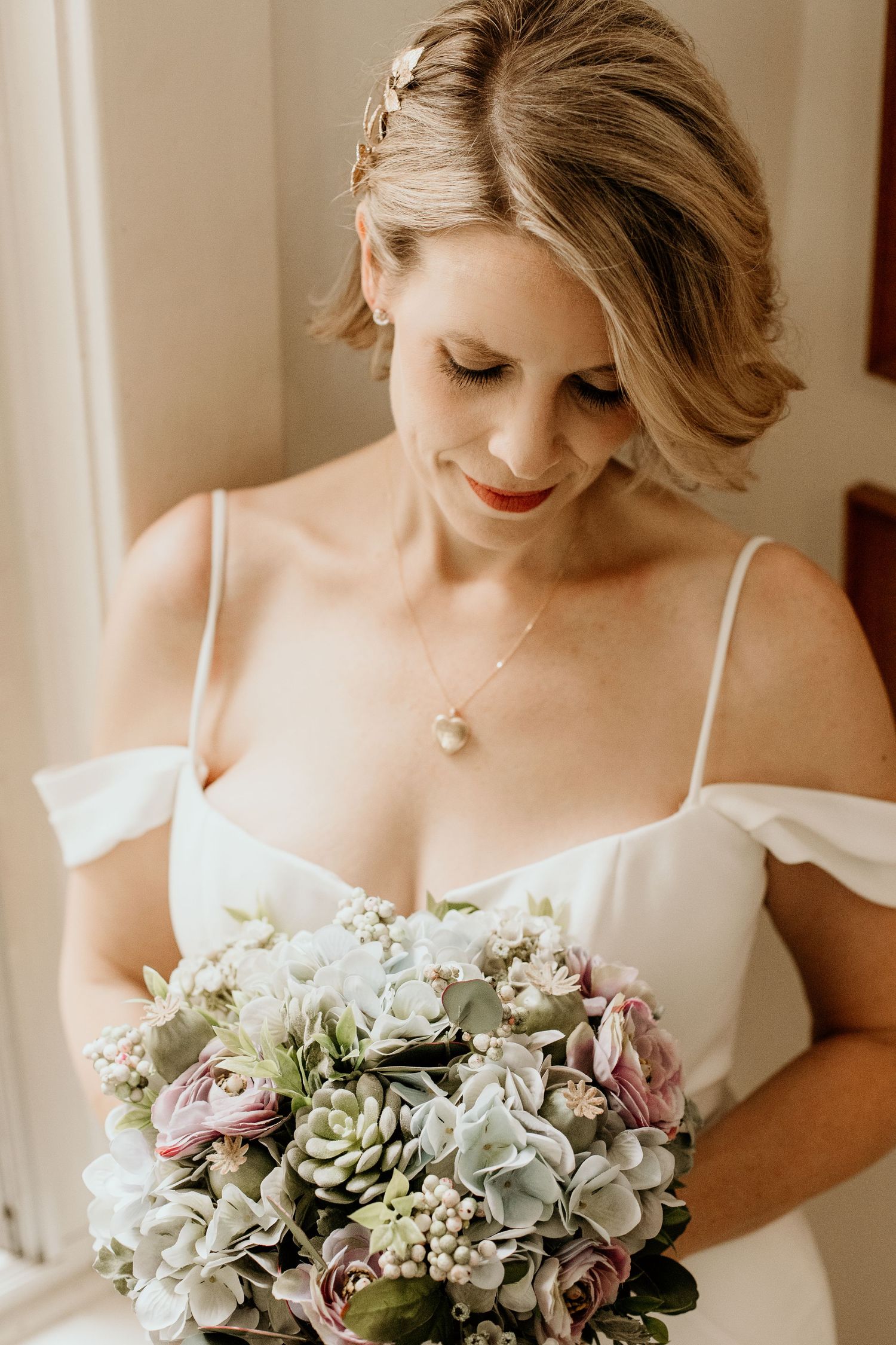 A new bride looking down at her wedding bouquet