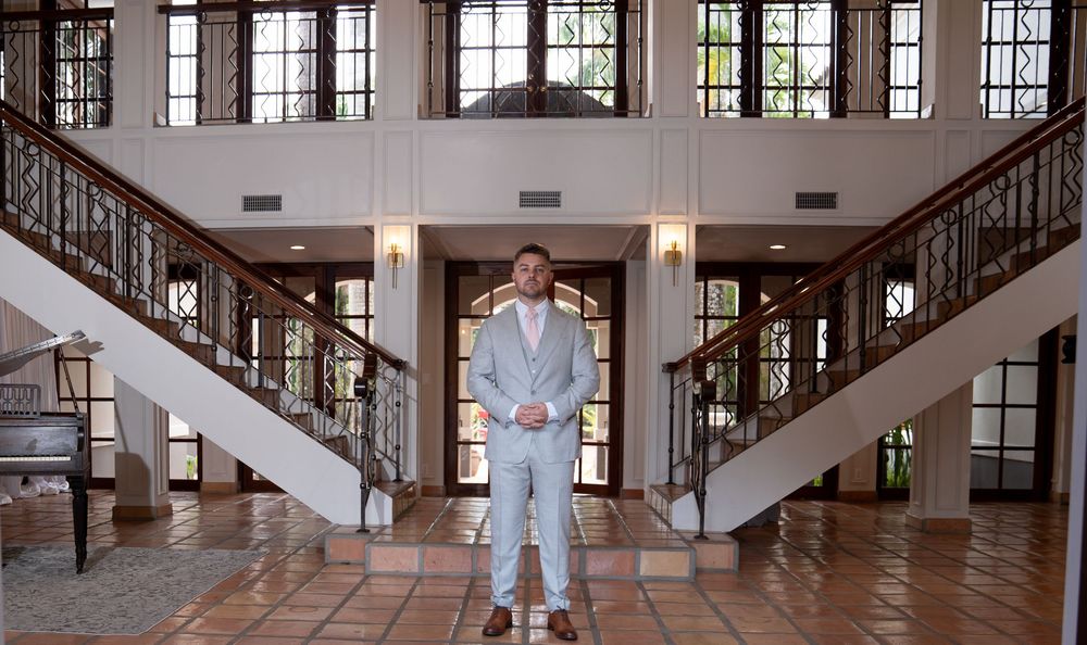 Five sequential photos showing a person standing in different poses in an elegant wood-paneled hallway.