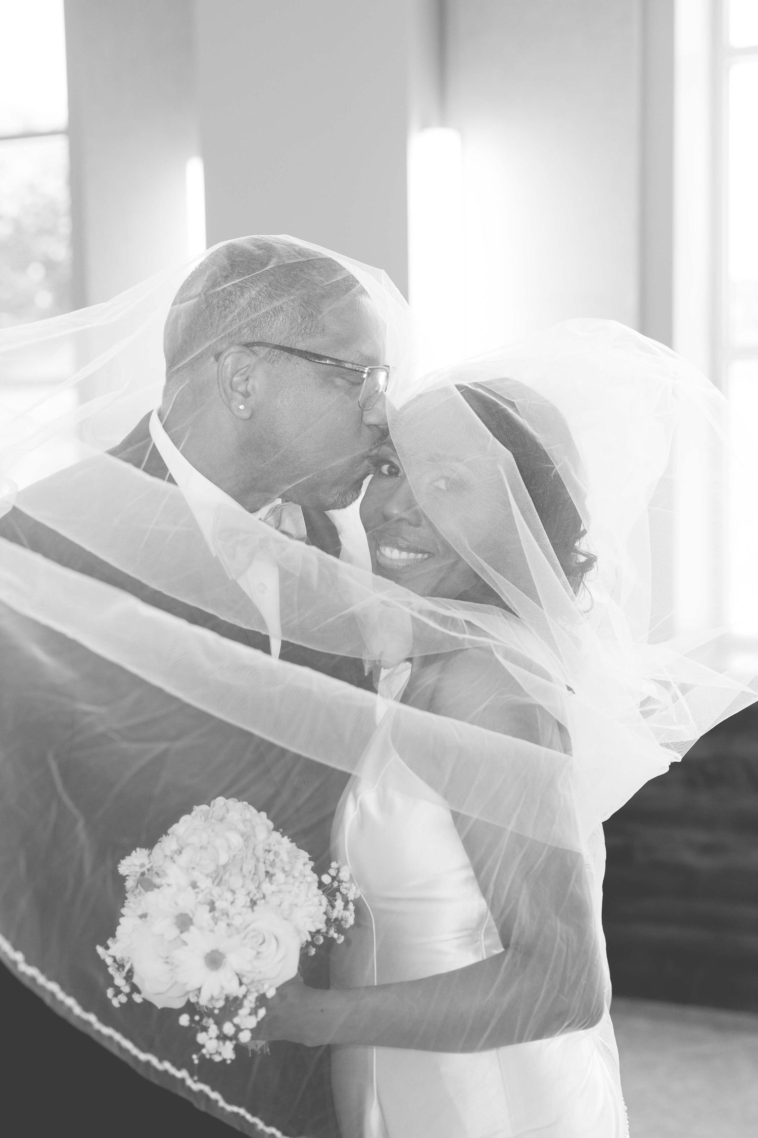 Romantic black and white wedding moment captured through a soft veil.
