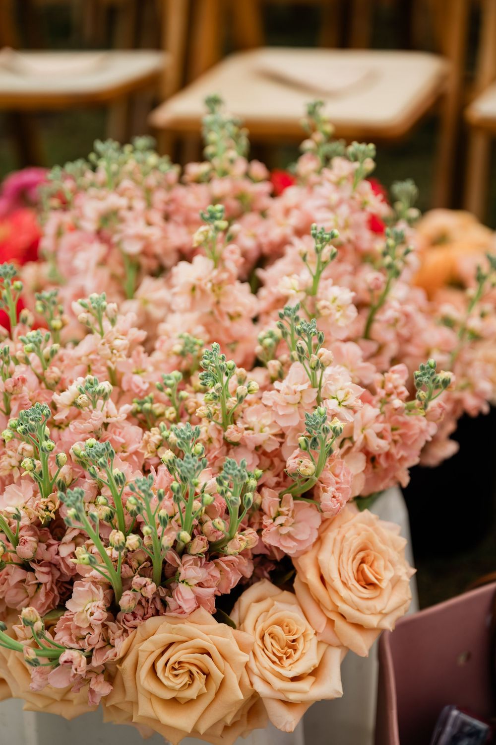 Close-up of pink floral arrangements with delicate peach roses and white baby's breath.
