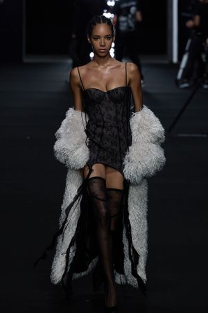 Fashion duo walks runway in contrasting white sheer dress and black tank top with jeans.