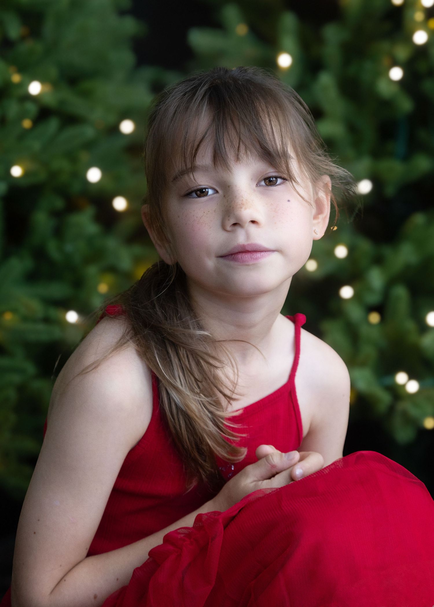 Hong Kong family Christmas Photo shoot portrait of a girl in front of a Christmas tree with bokeh fairy lights