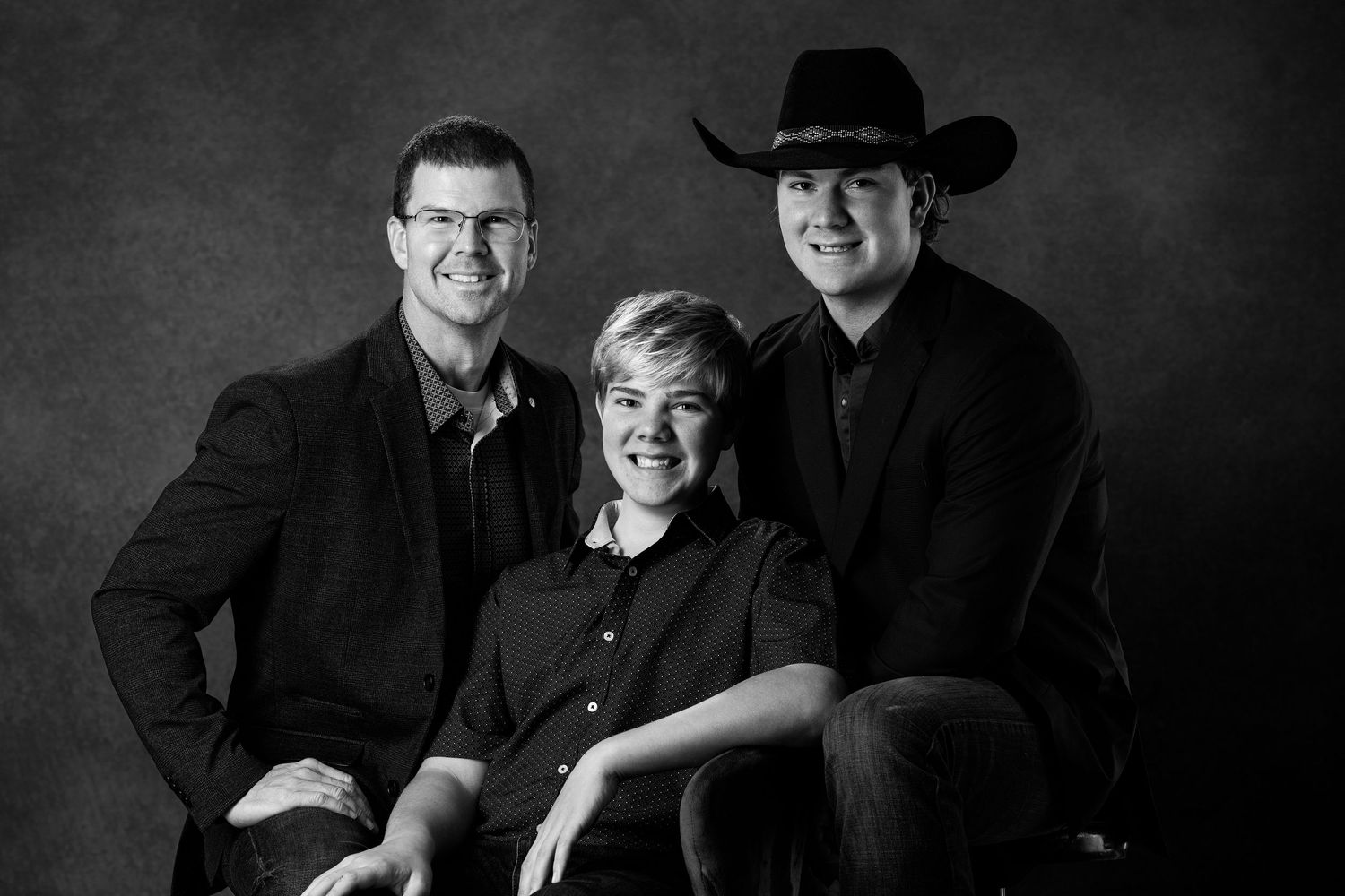 Studio portrait of three people in dark attire against grey background. branding North Platte Nebraska Photographer