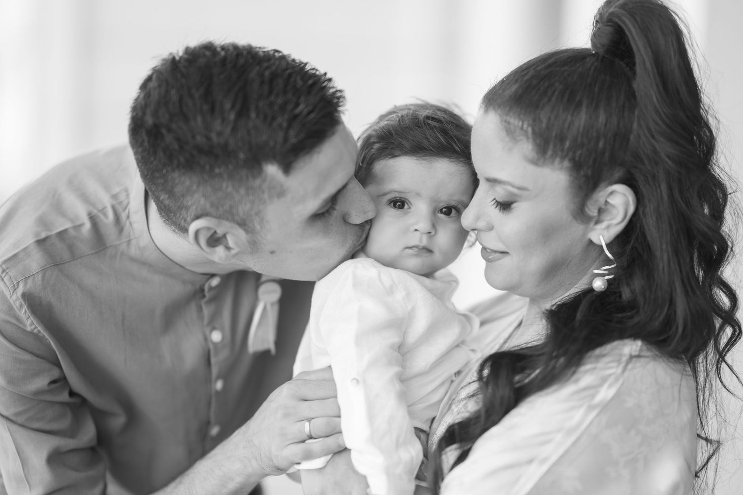 Black and white portrait of tender family moment with baby.