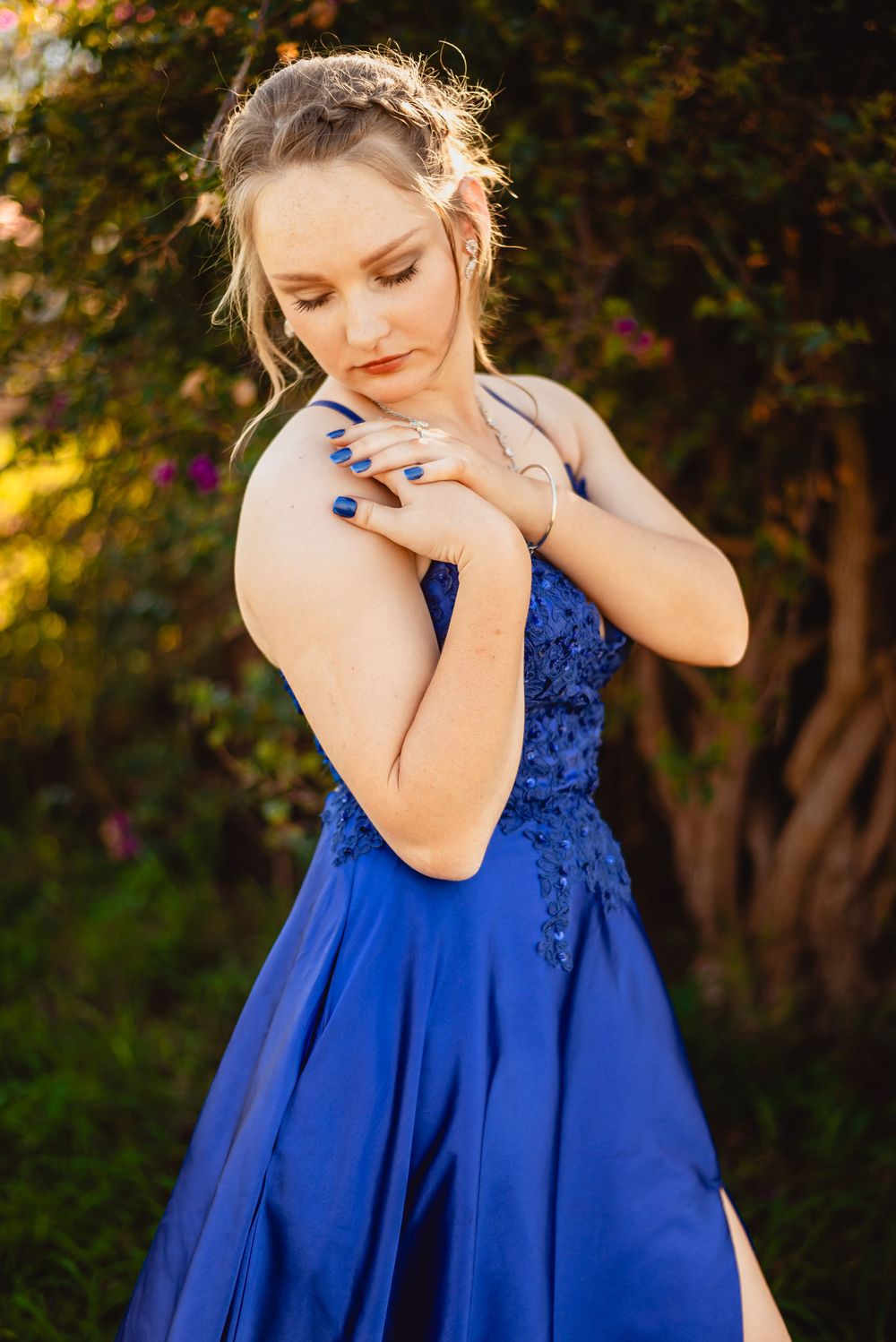 Artistic portrait showcasing a royal blue formal gown in warm sunset lighting.