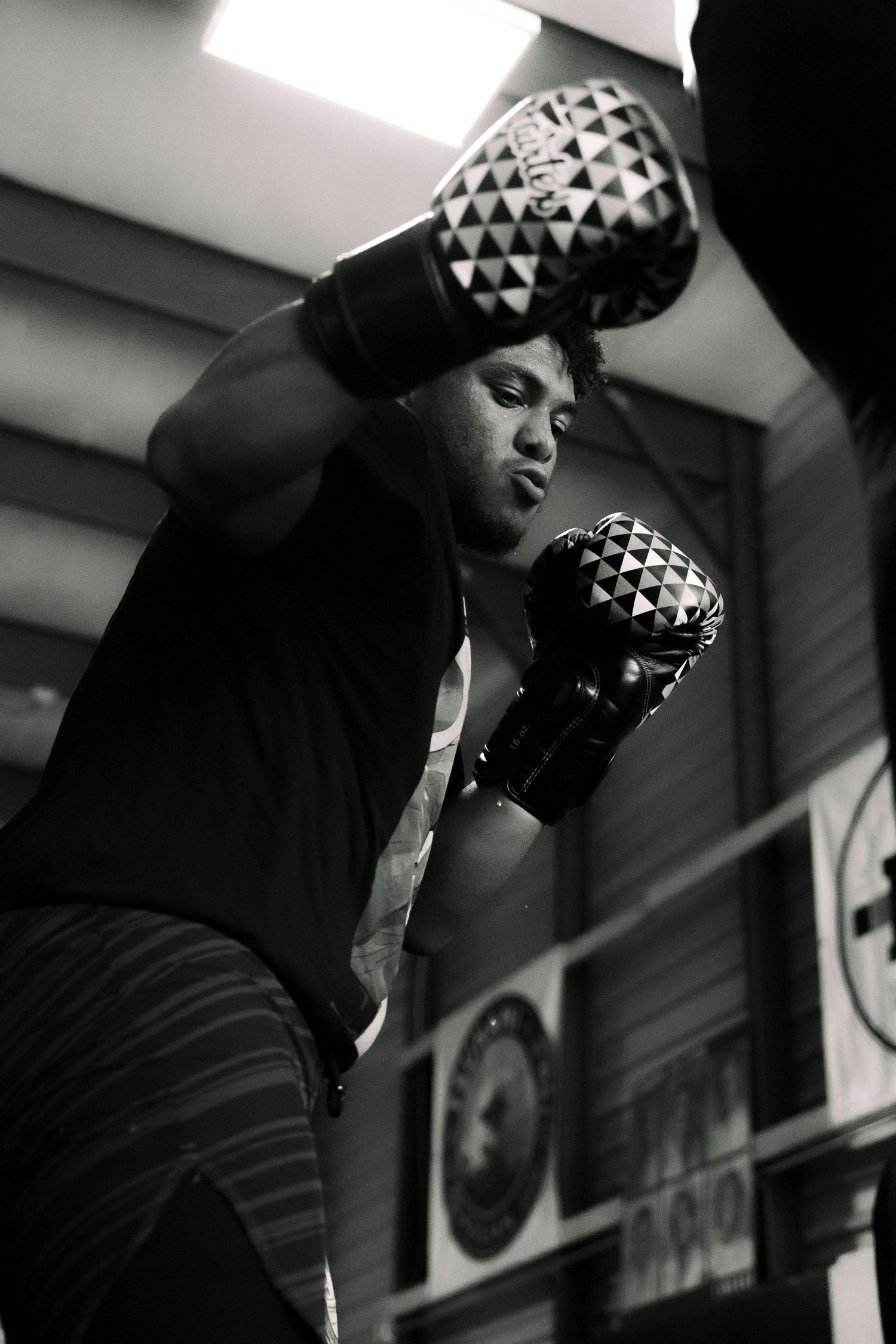 Boxer training with patterned gloves in black and white photography.