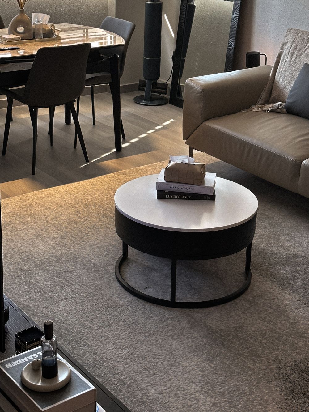 Contemporary living room with round coffee table, grey sofa and modern dining area.