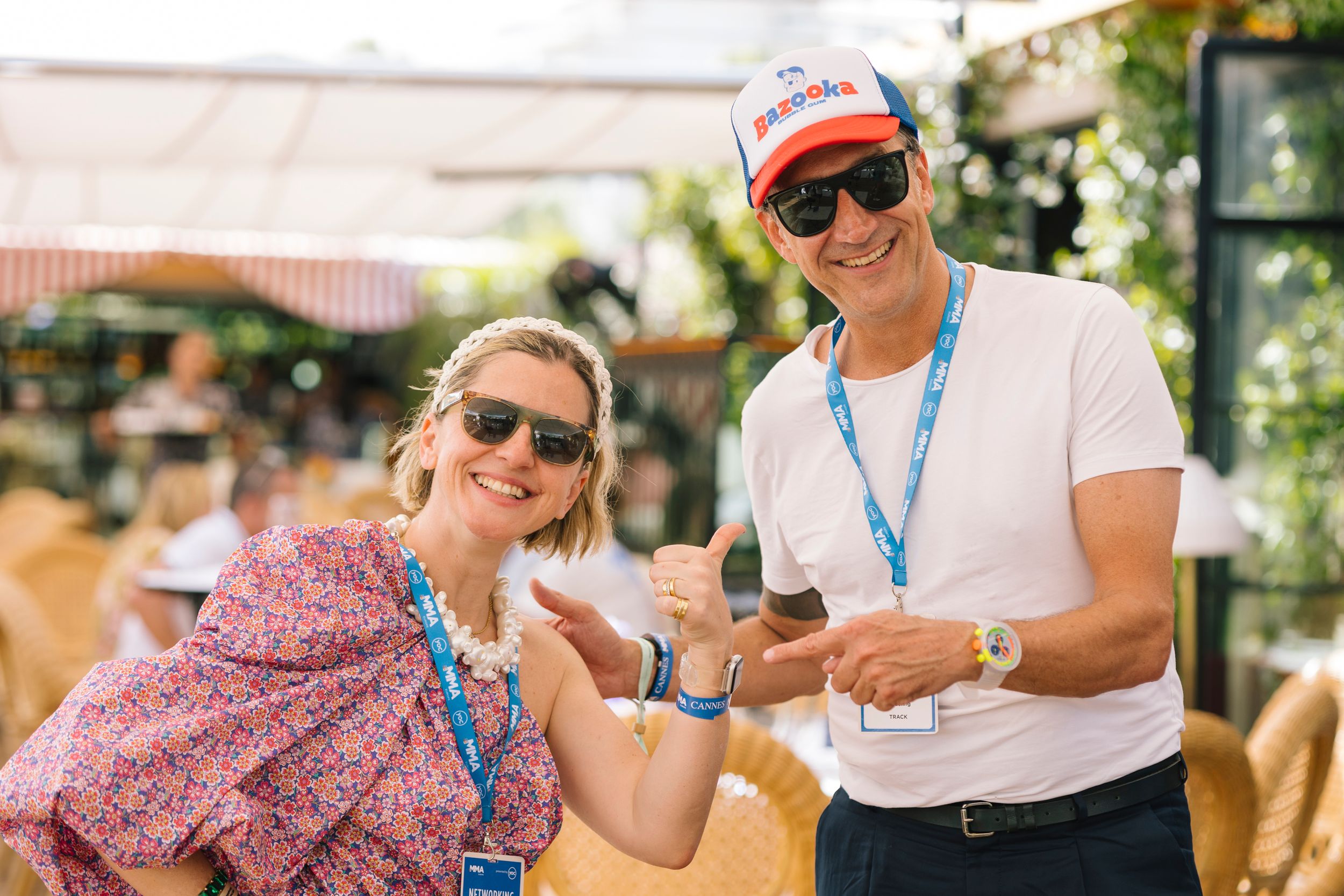 People enjoying an outdoor summer event wearing sunglasses and lanyards.