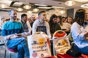 Group of attendees at an event holding promotional merchandise bags.